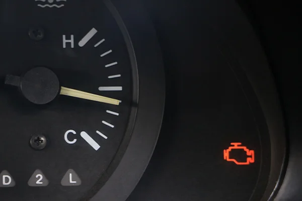 close up of a check engine light and temperature gauge