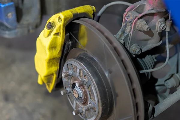 Yellow brake caliper mounted on brake rotor