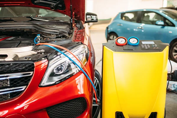 A/C refrigerant recharge equipment hooked up to vehicle 