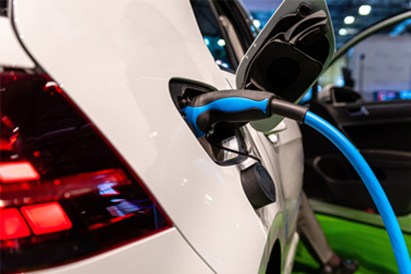 An electric vehicle is being recharged by an electric vehicle charging station.