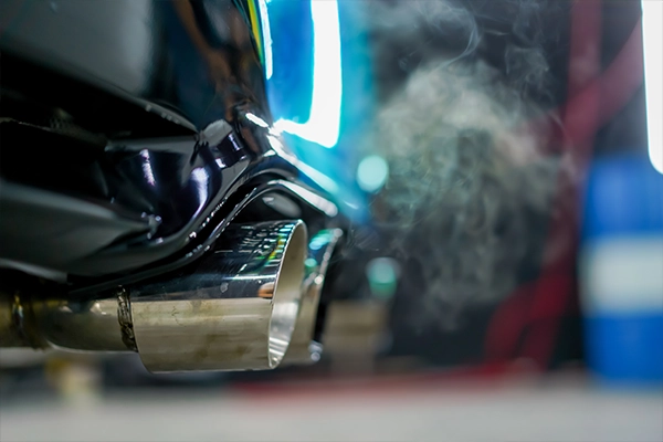 Close-up image of a car's exhaust pipe after emitting exhaust