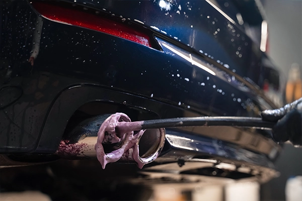 Close-up image of an exhaust pipe being cleaned